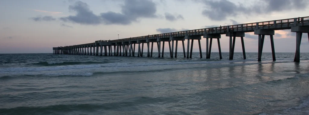Long pier reaching into the evening sea at Panama City Beach.