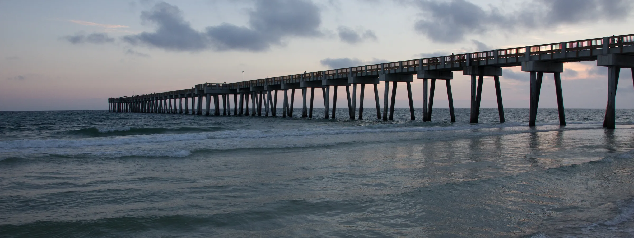 Long pier reaching into the evening sea at Panama City Beach.