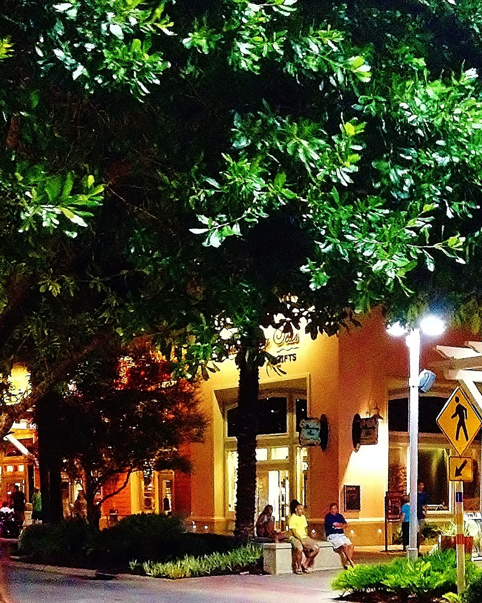 Visitors sitting near illuminated buildings and trees at Pier Park in 2016.