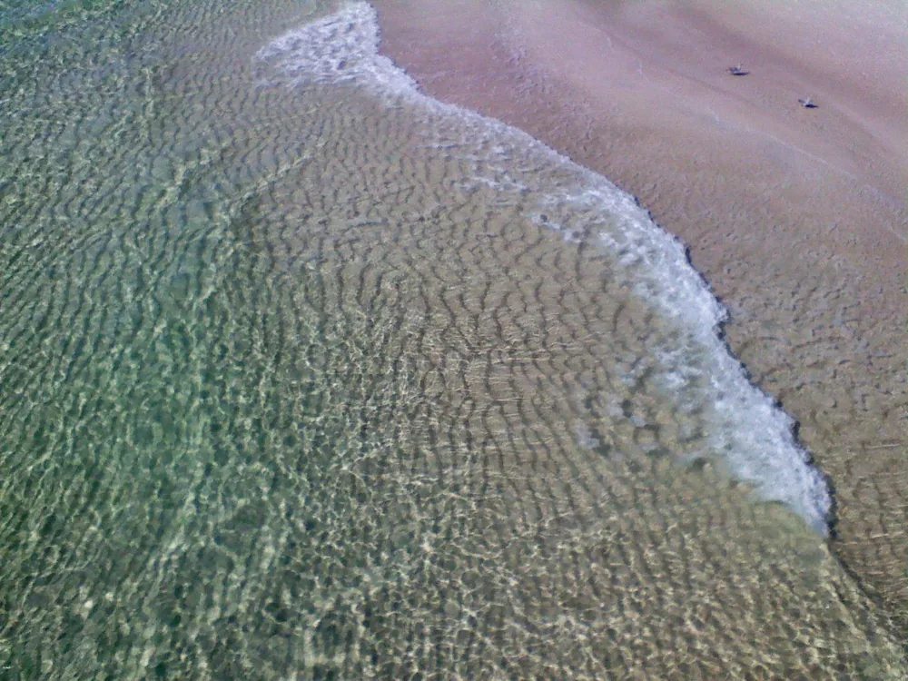 Shallow water and a small breaking wave seen from the pier at Panama City Beach.